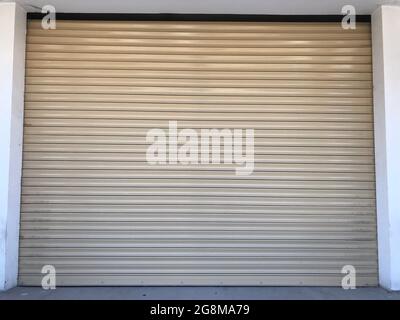 Beige color Mechanic or Hydraulic operated rolling shutter for an shop or garage or storage yard and this is front entrance undulated sheet Stock Photo