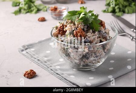 Georgian salad with eggplant and walnuts in a transparent bowl on a light gray background. Traditional appetizer of Georgian cuisine Stock Photo