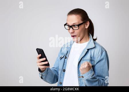 young man in glasses using smart phone Stock Photo