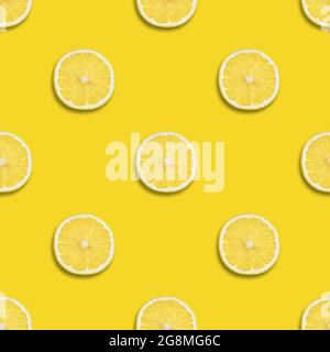 Seamless pattern with lemon on a yellow background. Lemon slices seamless texture for design. Summer background. Top view, flat lay. Stock Photo