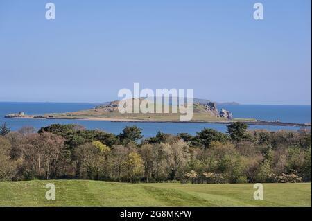Beautiful scenic bright view of the Ireland's Eye island with golf course and trees seen from Howth, Dublin, Ireland. Small uninhabited island Stock Photo
