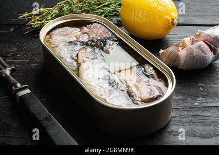 Sardine cans of preserves set, on black wooden table background Stock Photo
