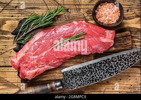 https://l450v.alamy.com/450v/2g8mpcx/raw-flank-beef-meat-steak-on-a-cutting-board-with-knife-wooden-background-top-view-2g8mpcx.jpg