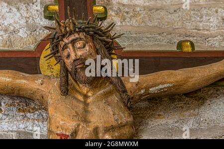 Jesus with the crown of thorns, an old colored crucifix from the 15th century with peeled painting, Borrie church, Sweden, July 16, 2021 Stock Photo