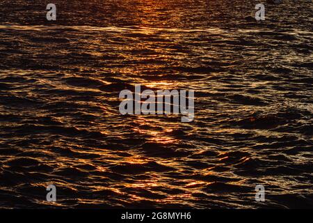 water surface of the sea ocean sunset glare glow leaks Stock Photo