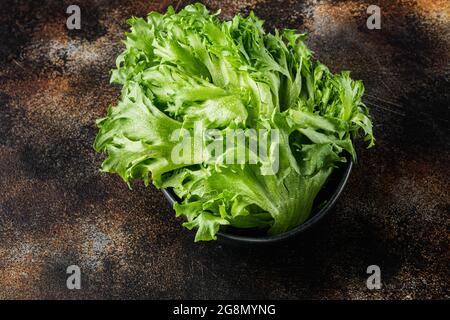 Fresh organic green batavia lettuce leaves, on old dark rustic background Stock Photo