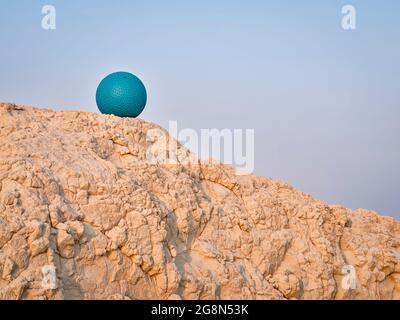heavy rubber slam ball filled with sand on at a clay cliff, outdoor exercise and fitness concept Stock Photo