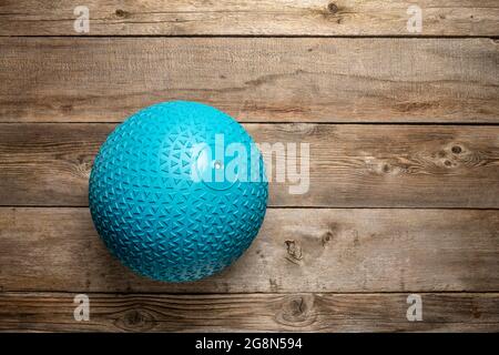 heavy rubber slam ball filled with sand on a rustic wooden deck, exercise and fitness concept Stock Photo