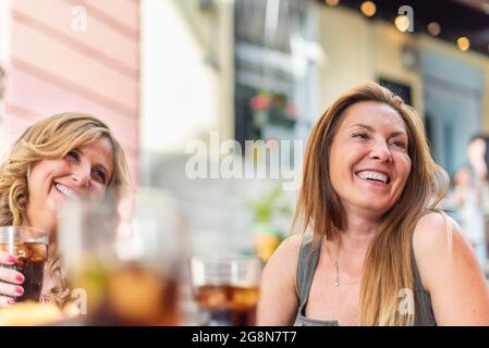 Middle-aged adult women in a cafe having drinks and chatting Stock Photo