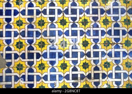Traditional glazed blue, yellow and white ceramic tiles or azulejos which cover many buildings in Lisbon, Portugal. These Portugese tiles have many di Stock Photo