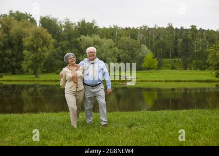 An elderly couple in casual clothes are walking outdoors Stock Photo