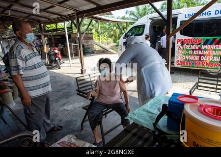 Kuala Lumpur, Malaysia. 21st July, 2021. A medical worker injects a dose of COVID-19 vaccine for a local resident in rural area of Sabak Bernam district, Selangor, Malaysia, July 21, 2021. Malaysia recorded a fresh high of 199 single-day death toll from COVID-19 on Wednesday, bringing the total deaths to 7,440, according to the Health Ministry. Credit: Chong Voon Chung/Xinhua/Alamy Live News Stock Photo