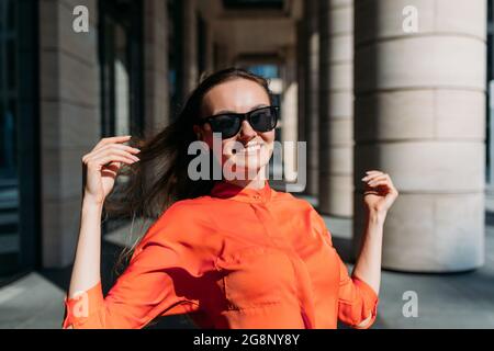 Caucasian girl in sunglasses and casual clothes smiling on a walk Stock Photo