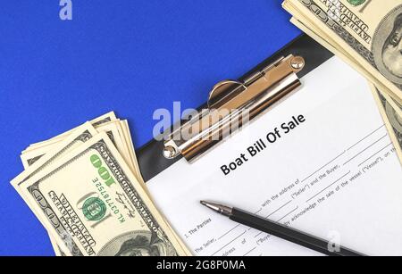 Buy new boat with official documents. Boat bill of sale agreement on blue office table with money and pen. Top view Stock Photo
