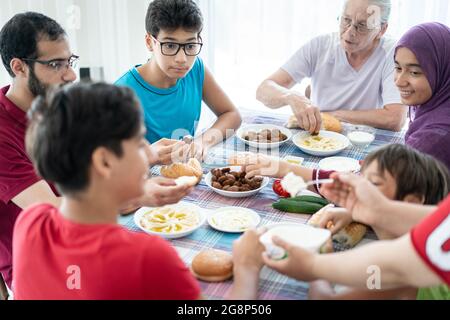 Happy family enjoying eating food in dining room Stock Photo