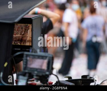 Glasgow, Scotland, UK. 21 July 2021.  PICTURED: A sneek peek long lens view of the directors monitor which is relaying aerial views from the camera high above the street looking down onto the film set. Filming on the set of Indiana Jones 5 in the middle of Glasgow city centre as the Hollywood blockbuster sets up Glasgow as New York City. A full production can be seen, with a large cast, producers and extras. The city centre has been changed so that all the shop fronts and building look like 1959 America. Credit: Colin Fisher Stock Photo