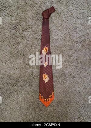 A vintage nicktie likely from the 1950s or 1940s with autumnal colors and with leaves. Stock Photo