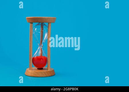 hourglass on blue on blue background Stock Photo