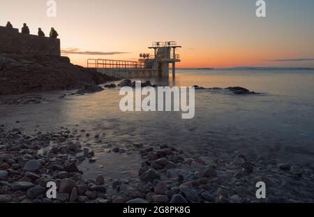 Beautiful morning orange sunrise scenery at Blacrock diving tower on Salthill beach in Galway city, Ireland Stock Photo