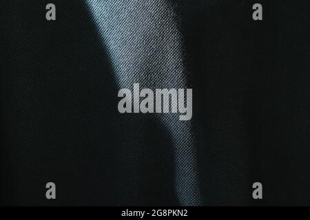 close up of sunlight spreading make shadow and shape on dark blue fabric background and texture Stock Photo