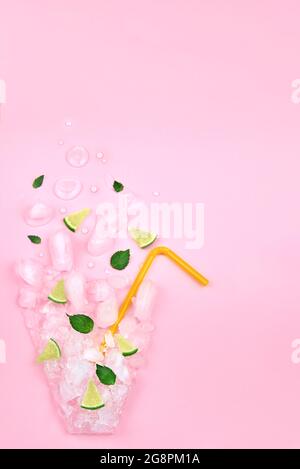 Flat lay composition, ice, mint, lime in the form of a glass on a pink background, copy space. Stock Photo