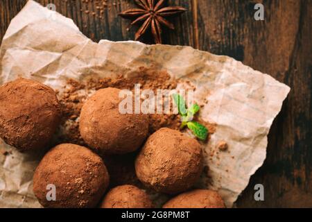 Homemade chocolate truffles on parchment paper, top view Stock Photo