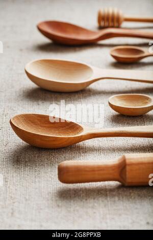 Natural wood spoons in a row on burlap fabric. Natural natural materials. Caring for the environment Stock Photo