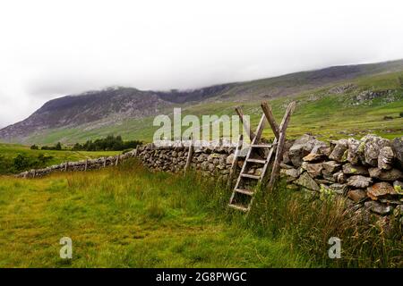 Ladder style over a dry stone wall on the walk between gwern gof isaf and Llyn Ogwen in Snowdonia national park. Stock Photo