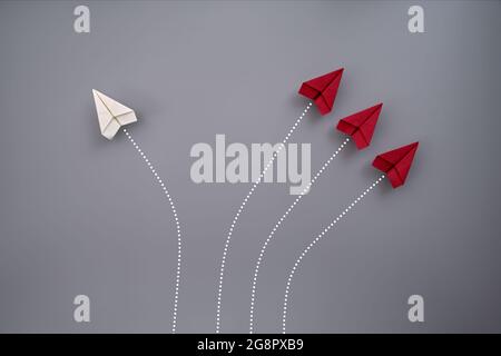 Four folded paper planes flying against gray background Stock Photo