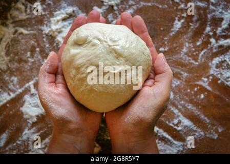 Preparing the Italian pizza. Kneading yeast dough pizza in hands Stock Photo