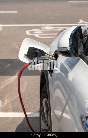 electric vehicle being charged at the supermarket car park Stock Photo