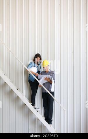 Two Asian engineers, man and woman, discussing in construction site Stock Photo