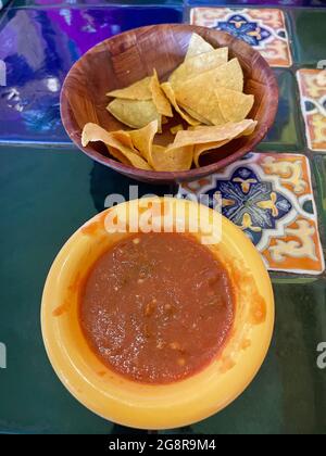 Mexican Salsa and chips in seperate bowls on a tiled table in a Mexican restaurant in Douglas AZ Stock Photo