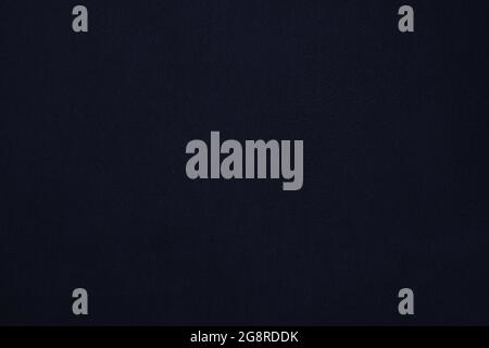 Texture of a dark blue flat fabric of polyester material. Fabric background in dark blue tone. Stock Photo