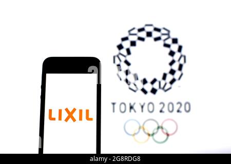 Spain. 20th July, 2021. In this photo illustration a Lixil Group Corporation logo seen displayed on a smartphone with the Tokyo 2020 Olympic Games logo in the background. Credit: SOPA Images Limited/Alamy Live News Stock Photo