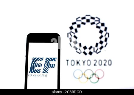 Spain. 20th July, 2021. In this photo illustration a EF Education First logo seen displayed on a smartphone with the Tokyo 2020 Olympic Games logo in the background. Credit: SOPA Images Limited/Alamy Live News Stock Photo