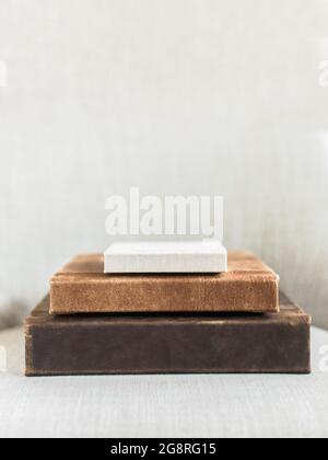 stack of three leather photo books on cream linen background Stock Photo