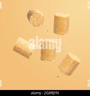 Sweet Brazilian peanut called Paçoca falling down on orange background. From June Celebration Stock Photo