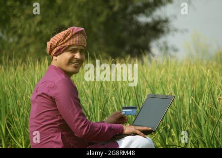 farmer,indian farmer,using laptop in agricultural field Stock Photo