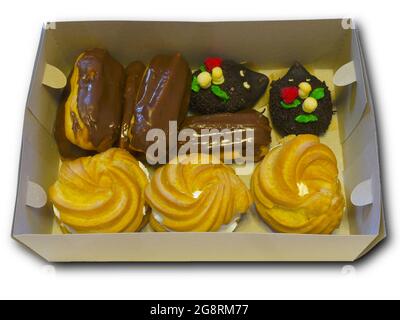 Box with cakes in order to quickly celebrate the holiday. Pack of confectionery with whipped cream and chocolate. Isolated object. Stock Photo