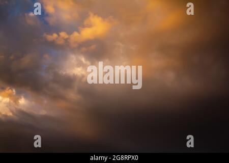 The sky before the storm with clouds of heavy dark dramatic tones. Colorful sky during natural disasters. Stock Photo