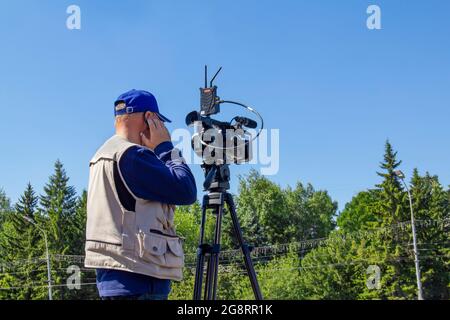 The cameraman is preparing to shoot the news. The operator shoots a movie. Stock Photo