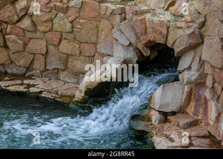 Mountain spring with pure mineral water. Ecologically clean water from the holy spring. Ecological tourism in virgin natural places of the world. Stock Photo