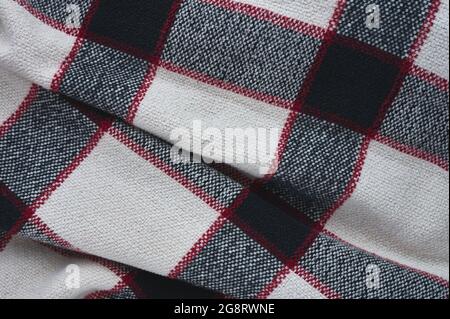 detail of a black, white and blue plaid blanket with red stripes Stock Photo