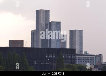 Manchester, UK. 22nd July, 2021. UK Weather: Thunder clouds and whispers of thunder at dusk in Manchester, England, UK, as the heatwave continues. High level view of new skyscrapers in central Manchester. Credit: Terry Waller/Alamy Live News Stock Photo