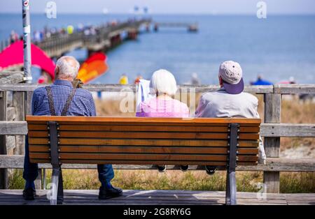 Prerow, Germany. 15th July, 2021. Three elderly holidaymakers are sitting on a bench at the pier. Credit: Jens Büttner/dpa-Zentralbild/ZB/dpa/Alamy Live News Stock Photo