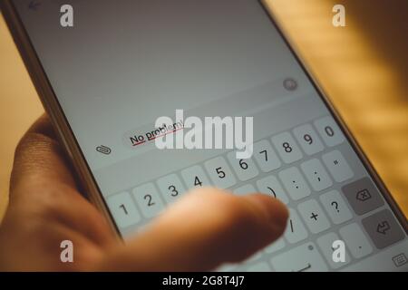 Human hand typing on a smartphone screen a message No problem Stock Photo