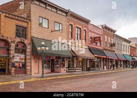 Deadwood SD, USA - May 31, 2008: Downtown Main Street. Harley davidson and other stores in brick buildings forming business row. Pedestrians. Commerci Stock Photo