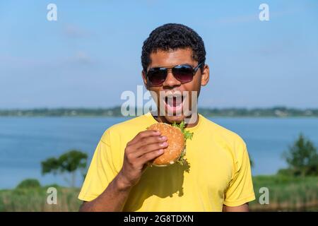 Brazilian man enjoying the taste of hamburger outdoor Stock Photo