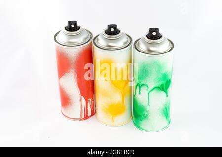 Three Colored Spray Paint Cans on White Background. Graffiti's Inventory - Close-Up Shot Stock Photo